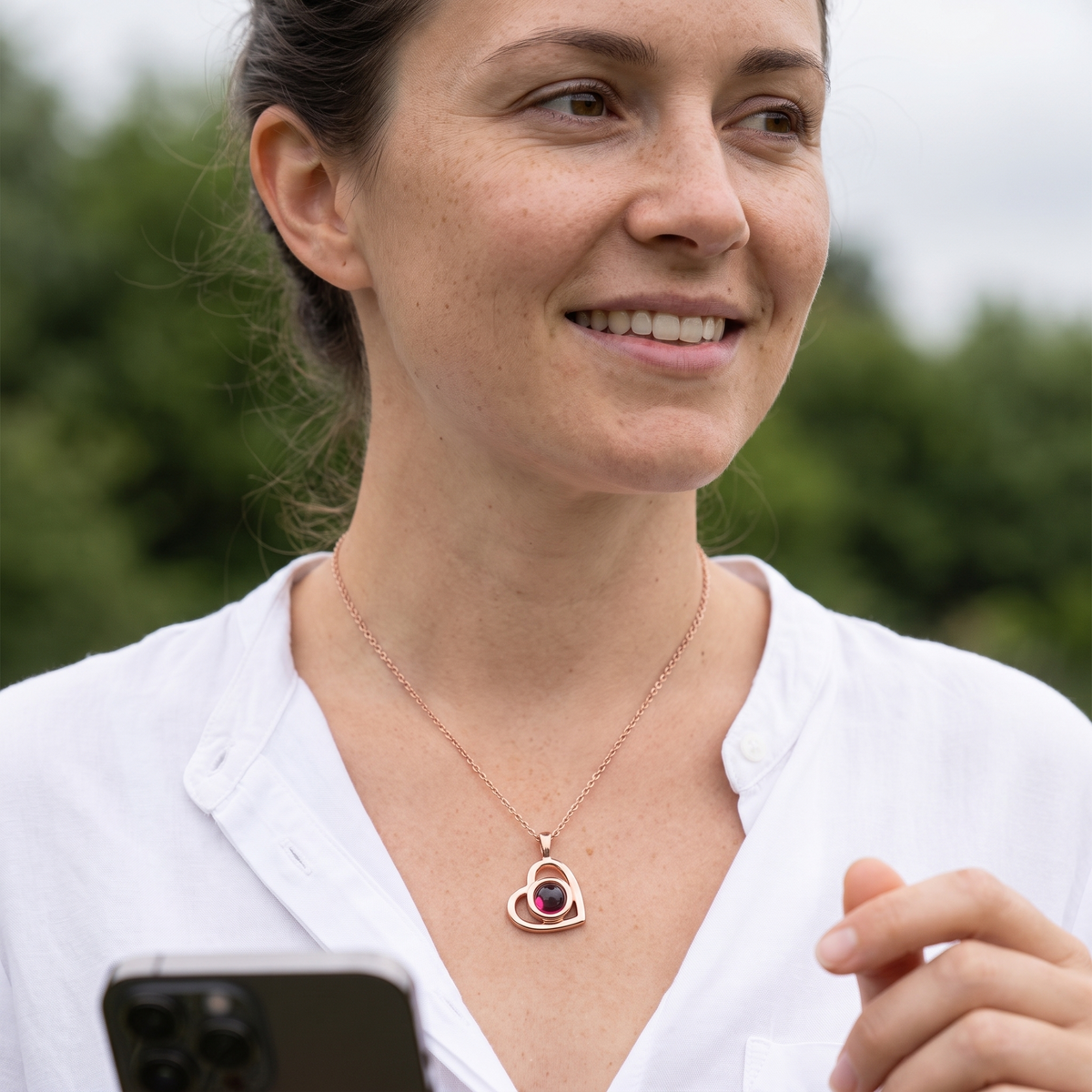 Rose gold Hidden Photo Necklace worn with an open white shirt outdoors
