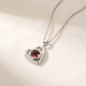 Silver Hidden Photo Necklace laid on cream linen