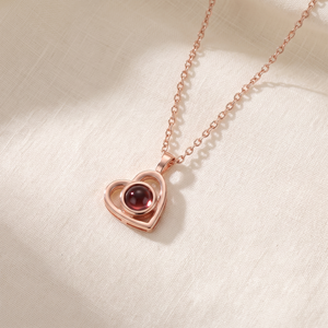 Rose gold Hidden Photo Necklace laid on cream linen
