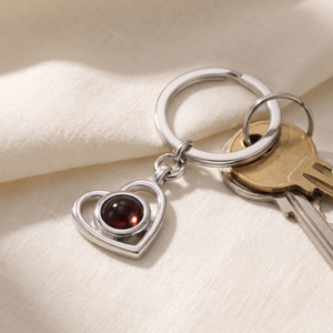 Silver Hidden Photo Keychain resting on cream linen beside a set of keys